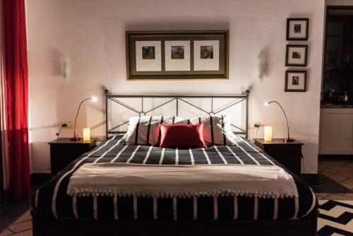 Schlafzimmer mit einem großen Bett und einem roten Kissen in der Unterkunft Loft Rural - Caserio De La Hondura in Alajeró