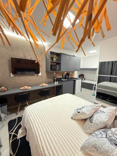 ein Schlafzimmer mit einem Bett und einer Küche in der Unterkunft Studio America Gardens in Rio de Janeiro