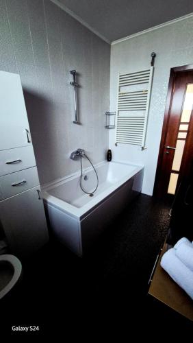 une baignoire blanche dans une salle de bain avec un lavabo dans l'établissement Ferval Confort Craiova, à Craiova