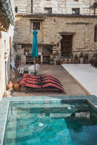 a swimming pool with an umbrella next to a building at DeMaJia. Casa entera: en Castillejo de Robledo in Castillejo de Robledo