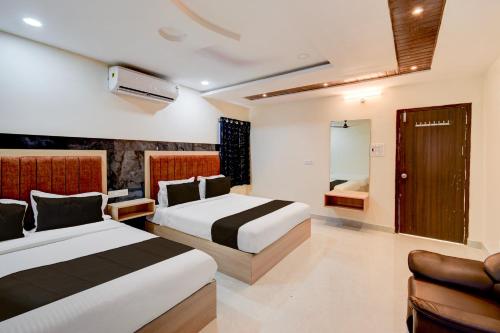 a hotel room with two beds and a chair at Hotel O RR Grand Luxury Rooms in Upal