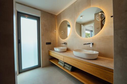 zwei Waschbecken im Bad mit zwei Spiegeln in der Unterkunft Villa Harmony Brela in Brela