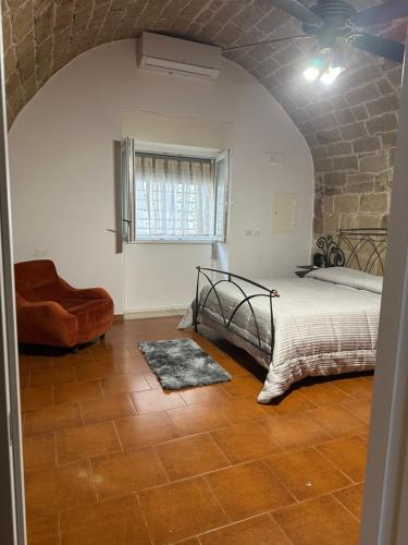 a bedroom with a bed and a chair and a window at casa Carlos in Bari Palese