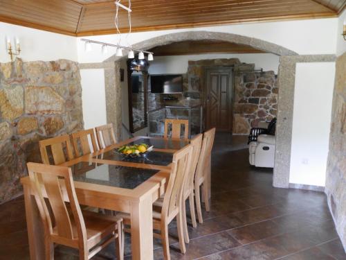 a kitchen and dining room with a wooden table and chairs at Casa do Alto in Magrelos