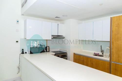 a kitchen with white cabinets and a white counter top at 2 Br Luxury duplex Canal View, 5 min to AUH Airport, Yas island , Raha mall in Abu Dhabi