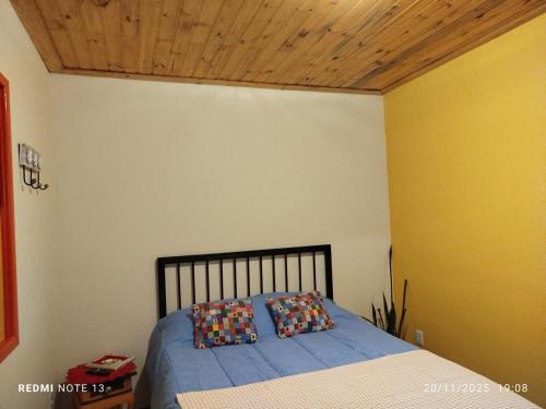 een slaapkamer met een bed met twee kussens erop bij Chalé Emília Costa in Ouro Preto