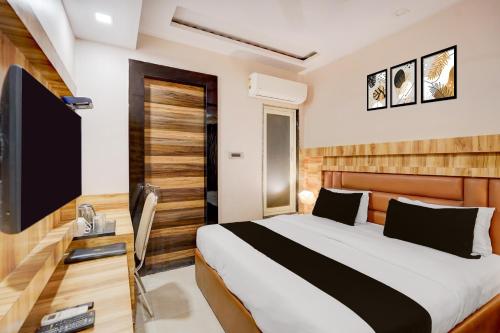 a hotel room with a bed and a television at Townhouse Oak CSJMU Kanpur Formerly Shree Dev Villa in Kaliānpur