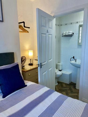 a bedroom with a bed and a bathroom with a sink at Glenthorne Guest House in Tenby