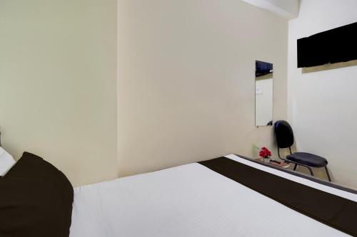 Un dormitorio con una cama blanca y una silla. en HOTEL O A.P PALACE, en Dīgha