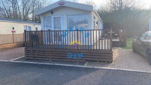 a small house with a gate with graffiti on it at Hikers Den, Brigham, Cockermouth, Cumbria in Cockermouth