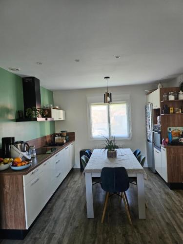 Chambre في Beaupréau: مطبخ مع طاولة وغرفة طعام