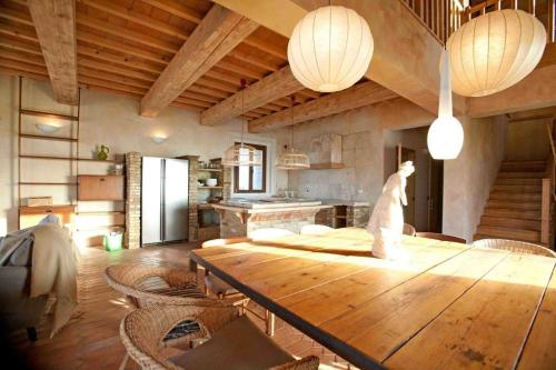 Großes Zimmer mit einem Holztisch und einer Küche. in der Unterkunft Ferienhaus in Volterra mit Terrasse, Grill und gemeinschaftlichem Pool in Volterra