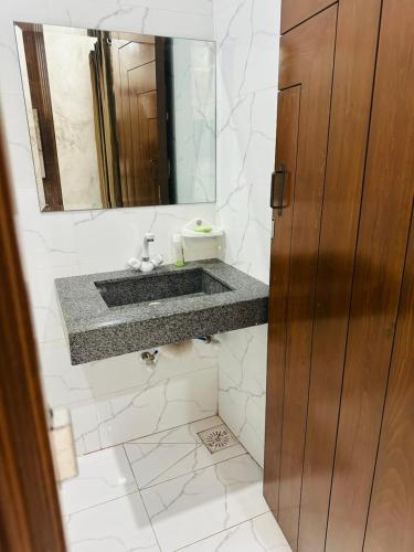 un bagno con lavandino e specchio di Peaceful Stay 2nd Home Appartment a Faisalabad
