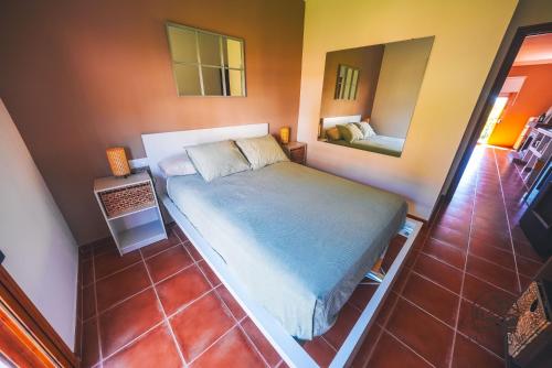 een kleine slaapkamer met een bed en een spiegel bij La Llave Rural in Benaocaz