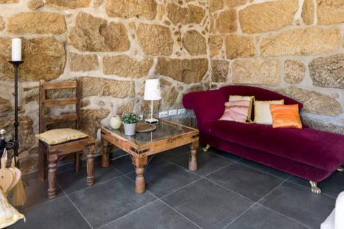 a living room with a purple couch and a table at Renoviertes Landhaus Für 4 Personen In Tondela in Tondela