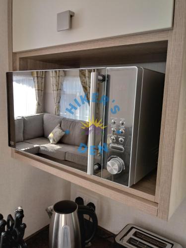 a microwave oven with a couch inside of it at Hikers Den, Brigham, Cockermouth, Cumbria in Cockermouth