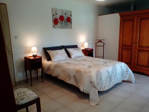 une chambre avec un lit avec deux tables de nuit et deux lampes dans l'établissement Gîte Braunis 4 étoiles, à Bourran