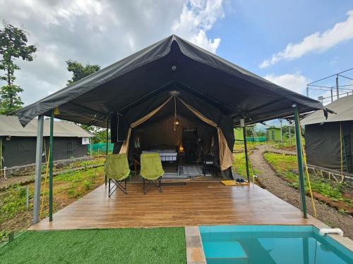 a black tent with chairs and a swimming pool at Streaming Offline Karjat - Premium Tent Stay with Private Plunge Pool in Jambrung 