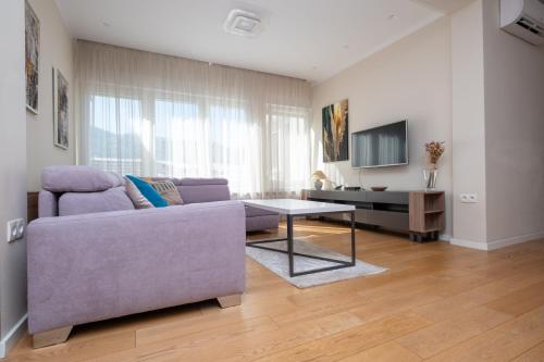 a living room with a purple couch and a table at Sanja & Mirza Apartments - Old Town Sarajevo in Sarajevo