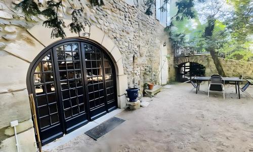 ein Gebäude mit einer schwarzen Tür und einem Tisch in der Unterkunft Gîtes du Parc in Vallon-Pont-dʼArc