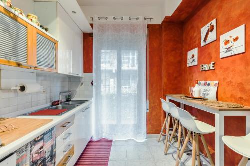 uma cozinha com paredes cor de laranja e um balcão com bancos em Raf Rhome Seaside - Center 200m to the Sea em Lido di Ostia