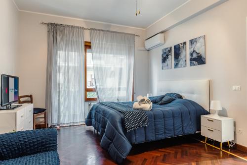 um quarto com uma cama azul e uma televisão em Raf Rhome Seaside - Center 200m to the Sea em Lido di Ostia