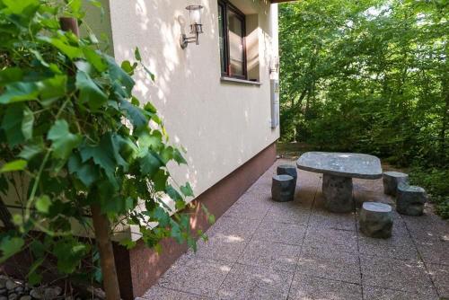 un banc en pierre assis à côté d'un bâtiment avec une fenêtre dans l'établissement Kleinhaus Am Rande Des Waldes, à Kranj