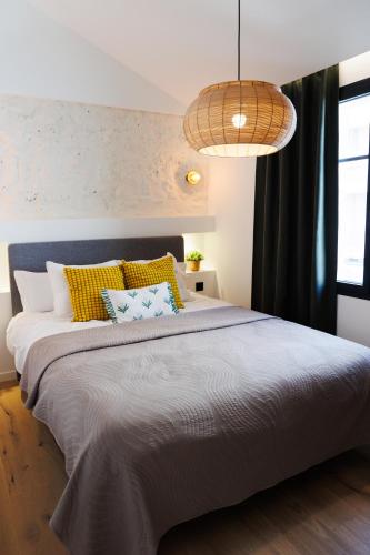 a bedroom with a large bed with yellow and blue pillows at Suite Cigale Jaune avec terrasse et piscine à Antibes in Antibes
