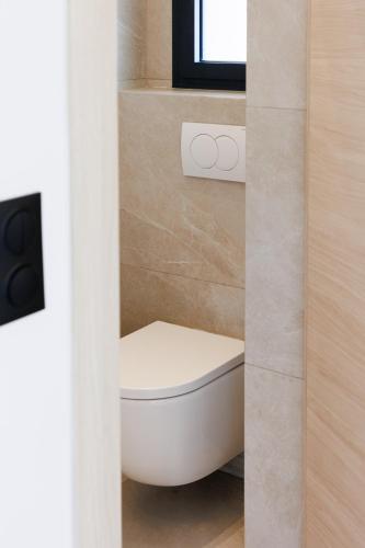 a bathroom with a white toilet in a room at Suite Cigale Jaune avec terrasse et piscine à Antibes in Antibes