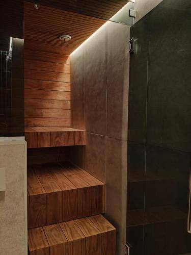 a walk in shower with wooden steps in a bathroom at Villa Kontio in Rovaniemi