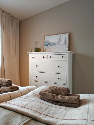 a bedroom with two beds and a dresser at Villa Kontio in Rovaniemi