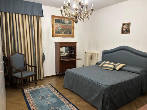 a bedroom with a bed and a chair and a chandelier at Castello Vinci - Dimora di Charme in Vetralla