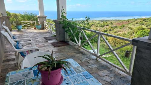 a balcony with a table and chairs and the ocean at Studio Amanda in Nouvelle Découverte