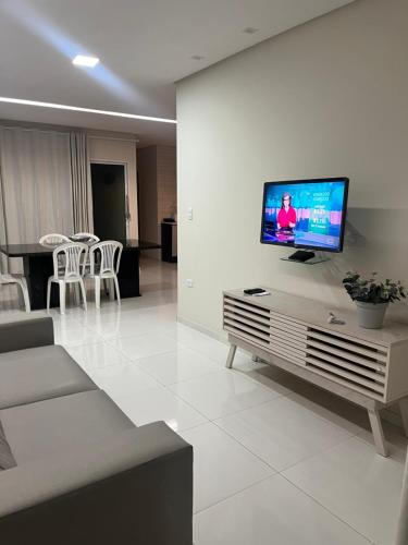 ein Wohnzimmer mit einem Flachbildfernseher an der Wand in der Unterkunft ParkMar III - São José, Maragogi in São José da Coroa Grande