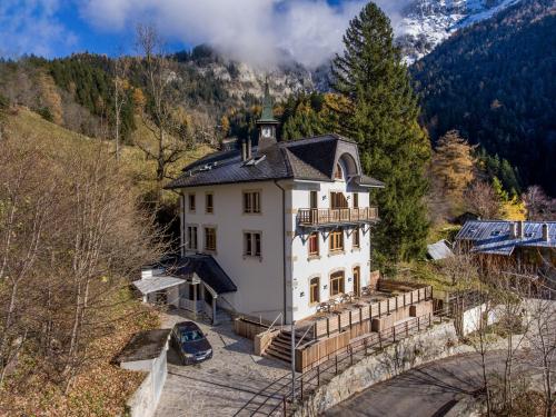 a house in the mountains with a car parked in front at Auberge de Morcles in Morcles