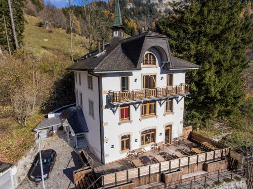 an aerial view of a large white house with a black roof at Auberge de Morcles in Morcles