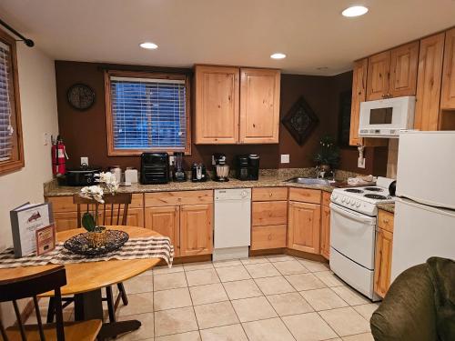 a kitchen with wooden cabinets and a table in it at Alpenglow One Bedroom One Bath – A09 in Ouray