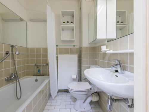Un baño con lavabo, inodoro y bañera. en Kwintebank - 0904, en Miami Wijk