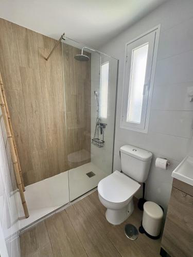 a bathroom with a white toilet and a shower at Vega Maspalomas - Escapada de sol, piscina y relax in San Bartolomé