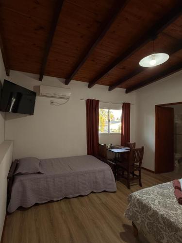 a bedroom with a bed and a table and a window at Babela 2 in Concordia