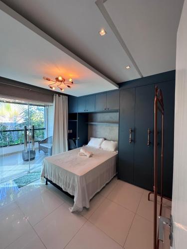 une chambre avec un lit et une grande fenêtre dans l'établissement Casa com Deck e Acesso ao Rio Espaço para Barco 4 Suítes e Área Gourmet, à Aracaju