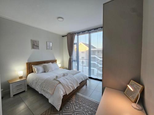 Un dormitorio con una cama y vista a un balcón. en Costa Bella, en Gqeberha