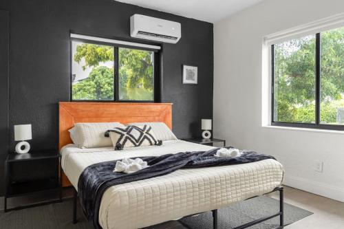 a bedroom with a bed with black walls and windows at Unit 1 Cozy 1BR Apt with Parking in Miami