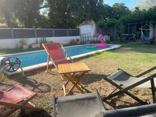 - un groupe de chaises assises devant la piscine dans l'établissement Studio with pool and quiet, non-shared garden, à Gardanne