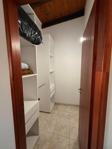 a walk in closet with white shelves and a door at Babela 2 in Concordia