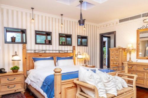 a bedroom with a wooden bed and a dresser at Luxury Stay Villa de Caesarea in Caesarea