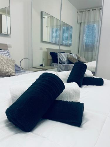 een groot wit bed met blauwe kussens erop bij Treviso Home Chic in Treviso