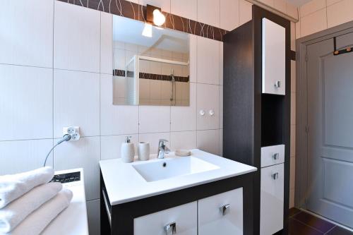 a bathroom with a white sink and a mirror at Maison de ville le Cocon d Alsace - garage inclus in Ribeauvillé