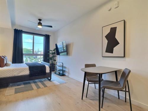 伯明翰Work Trip Ready, Tesla Rides, Gym, Near UAB的一间卧室，里面有一张床、一张桌子和几把椅子。