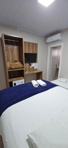 a bedroom with a bed with two towels on it at Hotel Querência in Dionísio Cerqueira